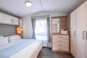 ein Schlafzimmer mit großem Bett und Fenster in der Unterkunft Mariri Heights Sequoia Cottage in Lower Moutere + 23 Fotos