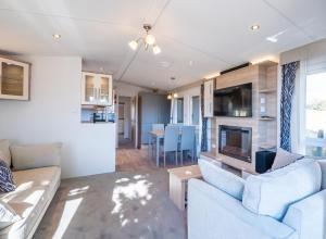 ein Wohnzimmer mit zwei Sofas und einem Kamin in der Unterkunft Mariri Heights Sequoia Cottage in Lower Moutere