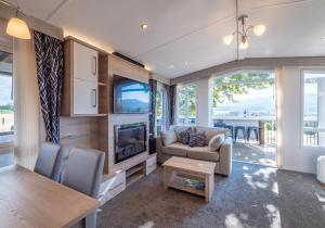 ein Wohnzimmer mit Sofa und Fernseher in der Unterkunft Mariri Heights Sequoia Cottage in Lower Moutere