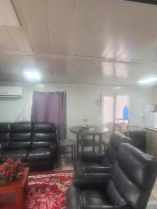 a living room with black leather furniture and a table at Avondale Place in Nuku‘alofa
