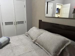a bedroom with a bed and a mirror at Apto 2 dorm - Requinte- Santos in Santos