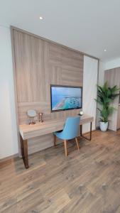 Camera dotata di scrivania con TV e sedia blu di Waterfront A La Carte Residence a Ha Long