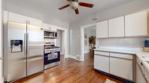 a kitchen with white cabinets and a stainless steel refrigerator at Chic Denver Family Retreat Free Parking & Prime Location in Denver