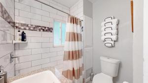 a bathroom with a toilet and a shower curtain at Chic Denver Family Retreat Free Parking & Prime Location in Denver