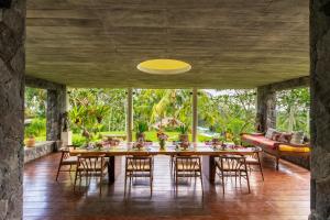 a dining room with a long table and chairs at Villa Palem in Tabanan