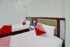 Кровать или кровати в номере Hotel O Wisma Kuta Karang Baru +40 фотографий