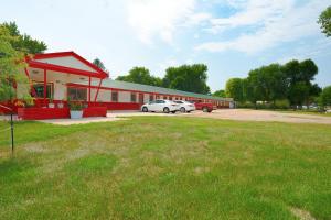 a red building with two cars parked in a parking lot at OYO Hotel Lamberton Hwy 14 in Lamberton