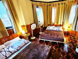 a bedroom with two beds and a fan at Guest Room 2B Transient Baguio Wifi Parking in Baguio