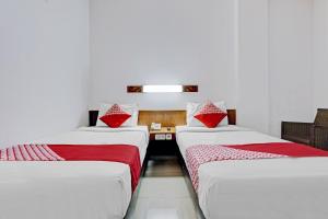 two beds sitting next to each other in a room at Collection O Riau Near Trans Studio Bandung Formerly Hotel Montameri in Bandung +29 photos