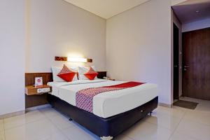 a bedroom with a large bed with red pillows at Collection O Riau Near Trans Studio Bandung Formerly Hotel Montameri in Bandung