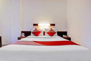 a bedroom with a white bed with red pillows at Collection O Riau Near Trans Studio Bandung Formerly Hotel Montameri in Bandung
