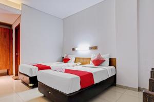 a bedroom with two beds with red and white sheets at Collection O Riau Near Trans Studio Bandung Formerly Hotel Montameri in Bandung