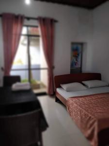 a bedroom with two beds and a window at Family Bricks Bungalow in Ratnapura
