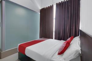 sypialnia z łóżkiem z białymi i czerwonymi poduszkami w obiekcie Hotel O Bukittinggi near Padang Luar formerly New Aedo w mieście Padangluar