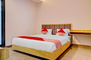 a bedroom with a bed with red pillows on it at Capital O 90635 Tango Juliet Residence in Jakarta