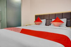 a bed with red pillows on top of it at Capital O 90635 Tango Juliet Residence in Jakarta
