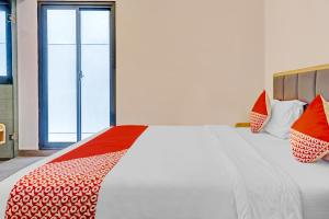 a white bed with red and white pillows on it at Capital O 90635 Tango Juliet Residence in Jakarta