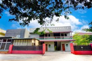 棉兰Hotel O Skyview Near Universitas Sumatra Utara ( USU ) Formerly Juma Ciger的一座有红色地基的建筑,设有阳台