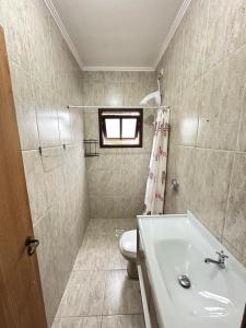 a bathroom with a toilet and a sink at Pousada barcelos in Florianópolis