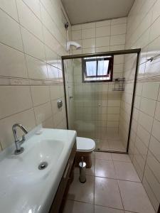 a bathroom with a sink and a shower and a toilet at Pousada barcelos in Florianópolis