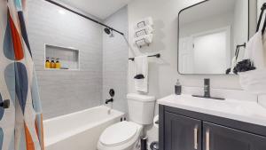 a white bathroom with a sink and a toilet and a tub at Spacious Family Retreat in Denver in Denver