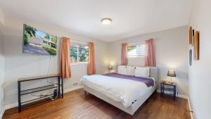a bedroom with a large bed and two windows at Stunning Upper Family Unit with King Beds & Yard in Denver
