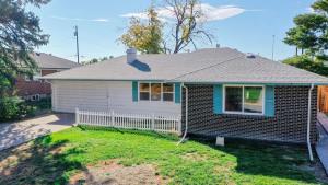 a small house with a fence in a yard at Stunning Upper Family Unit with King Beds & Yard in Denver