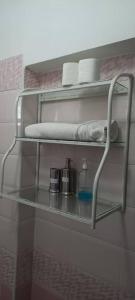 - une étagère dans une salle de bains pourvue de serviettes et d'une bouteille dans l'établissement The Coffee Residences at KINGS MILLENNIUM APARTMENTS, near JKI Airport 3 Bedroom, à Nairobi