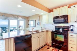 a kitchen with a sink and a stove at Oceans Of Amelia - 105 in Fernandina Beach +18 photos