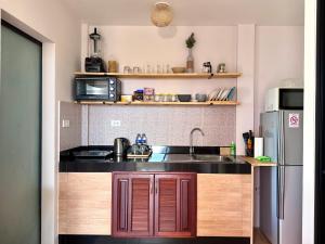 a kitchen with a sink and a refrigerator at Secret Place in Panwa Beach +29 photos
