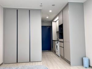 een kamer met een schuifdeur met een wasmachine en droger bij DDMOP-Seoul in Seoul