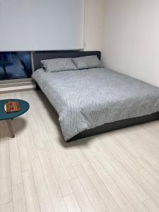 een slaapkamer met een bed en een tafel op een houten vloer bij DDMOP-Seoul in Seoul