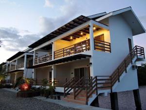 a white house with stairs in front of it at Papakit's Marina and Fishing Lagoon powered by Cocotel in Liloan