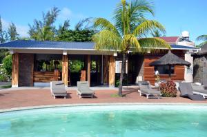 a resort with a pool and chairs and a house at Casa Florida Hotel & Spa in Pereybere