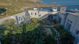 an aerial view of a house and the ocean at Klein-Hangklip Remote Mountain Studio Cottage in Rooiels