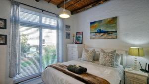 a bedroom with a bed and a large window at Klein-Hangklip Remote Mountain Studio Cottage in Rooiels