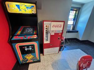 a cocacola arcade game next to a claw machine at Cool, Retro Getaway in Heart of Downtown in Bellefonte
