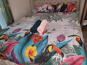 a bed with a colorful comforter with birds on it at 4 pieces disponible in Nanterre