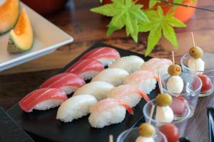 a plate of sushi on a table at Biei Shirogane Onsen Hotel Park Hills in Biei +72 photos