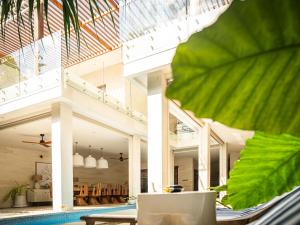 a house with a pool and a large green leaf at Villa Ivaya 8 in Sanur