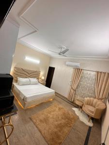 a bedroom with a bed and a chair and a piano at Golden Horizon Suite in Lahore