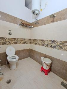 a bathroom with a toilet and a bucket in it at LD Guest House, Ayodhya in Ayodhya