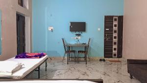 a room with a table and chairs and a blue wall at LD Guest House, Ayodhya in Ayodhya