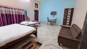 a bedroom with a bed and a couch and a table at LD Guest House, Ayodhya in Ayodhya