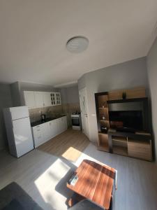 a living room with a table and a kitchen at Уютен Апартамент in Sofia