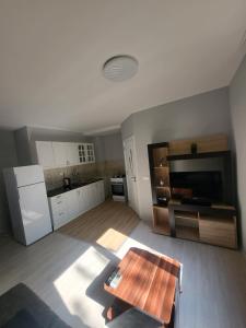 a living room with a table and a kitchen at Уютен Апартамент in Sofia