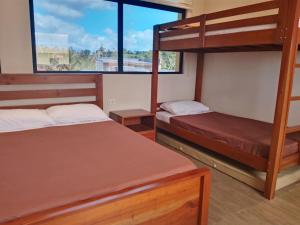two bunk beds in a room with a window at Cristina's Holiday Home in Tagaytay +5 photos