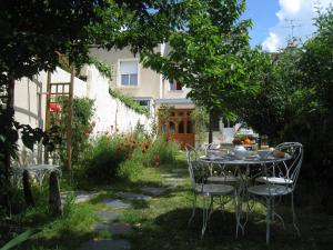 una mesa y sillas en el patio de una casa en Le Petit Quernon en Angers