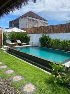 ein Swimmingpool im Hinterhof eines Hauses in der Unterkunft NOMAD Tropical Hotel Canggu in Dalung