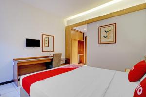 a hotel room with a bed and a desk at Collection O Riau Near Trans Studio Bandung Formerly Asteria Hotel in Bandung